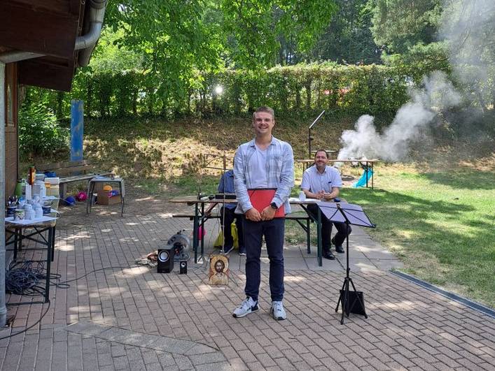 Sommerfest 2025 Begleitetes Wohnen in Familien (BWF) – Eine Person steht neben einem Notenständer, eine andere Person sitzt dahinter.  